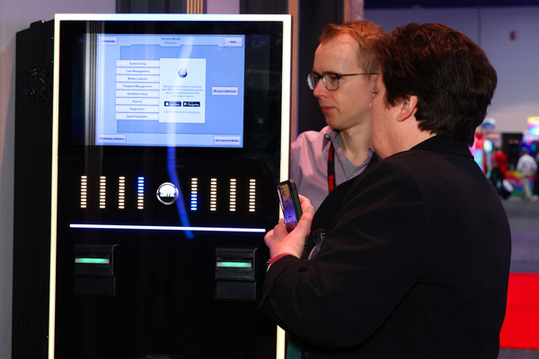 A photo of an exhibitor giving an attendee an inside view of a video jukebox